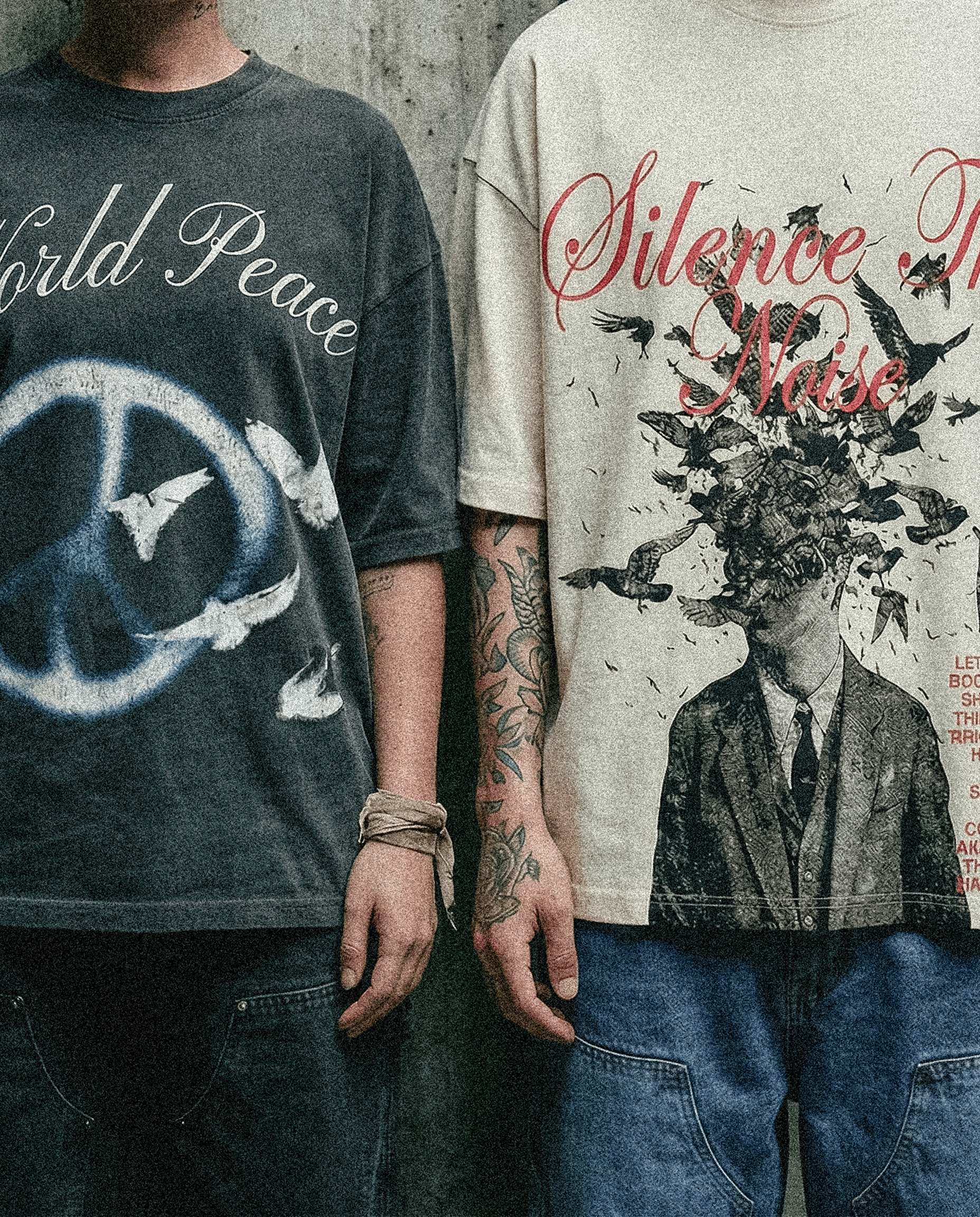 Two models wearing graphic T-shirts and denim jeans, shown from chest to waist against a textured wall